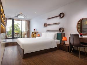 um quarto com uma cama branca e uma secretária em MoonLight Tay Ho em Hanói