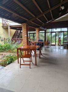 un patio con mesas y sillas de madera y ventanas en Sea view homestay villa, en Ấp Ðại Tài (2)