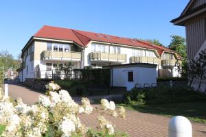 a large white building with a red roof at Birkenhof App 67 in Wustrow