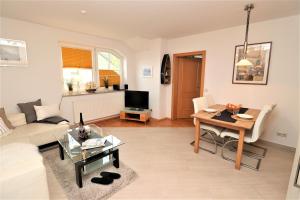 ein Wohnzimmer mit Sofa und Tisch in der Unterkunft Birkenhof App 74 in Wustrow