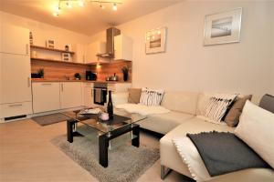 ein Wohnzimmer mit Sofa und Tisch in der Unterkunft Birkenhof App 74 in Wustrow