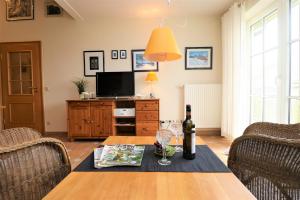 Un comedor con una mesa con una botella de vino. en Birkenhof App 71, en Wustrow