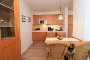 Una cocina con una mesa y sillas en una habitación. en Oewern Diek App 06, en Wustrow