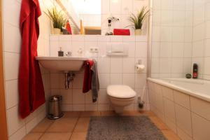 Un baño con lavabo, inodoro y bañera. en Oewern Diek App 03, en Wustrow 7 fotos más