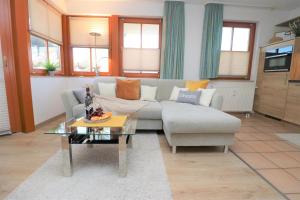 una sala de estar con un sofá y una mesa en Oewern Diek App 03, en Wustrow