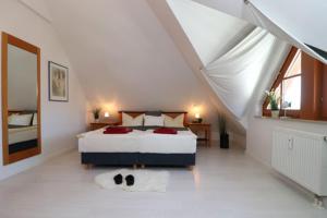 a white bedroom with a bed and a window at Oewern Diek App 09 in Wustrow