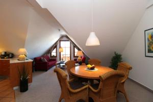 a living room with a wooden table and chairs at Oewern Diek App 09 in Wustrow