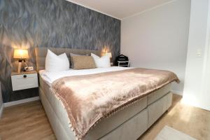una camera da letto con un grande letto con una parete grigia di Oewern Diek App 10 a Wustrow