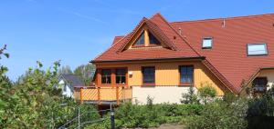 a house with a red roof at Oewern Diek App 05 in Wustrow