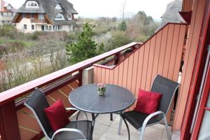 eine Terrasse mit Tisch und Stühlen auf einem Balkon in der Unterkunft Oewern Diek App 58 in Wustrow