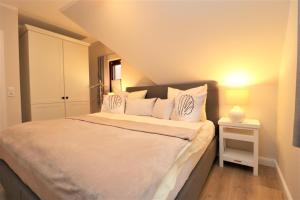 ein Schlafzimmer mit einem großen Bett und weißen Kissen in der Unterkunft Oewern Diek App 58 in Wustrow