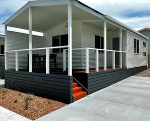 a mobile home with a porch and stairs to it at Big4 Ulladulla Beachside Holiday Park in Ulladulla