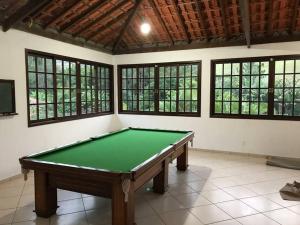 帕蒂杜阿爾費里斯的住宿－Sítio com 3 suítes +3 quartos, campo e piscina.，带窗户的客房内的台球桌
