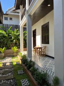 a patio of a house with a table and chairs at Villa Namkhan Heritage in Luang Prabang