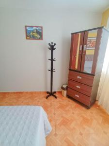 a bedroom with a dresser and a bed and a cabinet at Confortable habitación doble frente al Aeropuerto in Lima