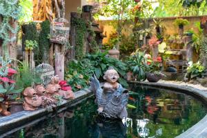 a garden with a pond with a group of statues at At Chiang Mai Hotel in Chiang Mai