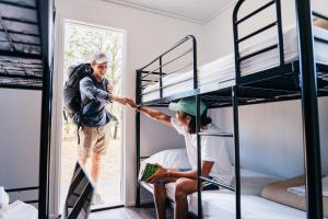 two men are in a bunk bed room at KangaROOMS Noosa Everglades YHA in Cootharaba