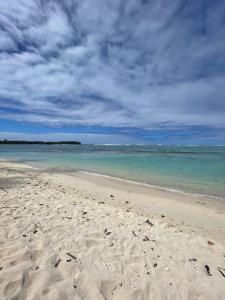 a sandy beach with the ocean and a cloudy sky at Parea Lodge Huahine BUNGALOW F2 #Miti in Parea +3 photos