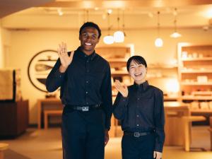 two men are clapping their hands in a store at MIMARU SUITES KYOTO SHIJO in Kyoto