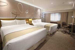 Postel nebo postele na pokoji v ubytování Kaohsiung Chateau de Chine Hotel