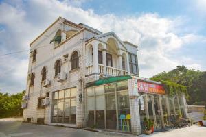 a large white building with windows on a street at Huan Bei 88 Homestay in Jincheng