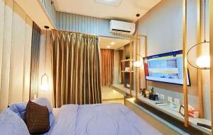 um quarto com uma cama e uma televisão de ecrã plano em Ayodhya Studio at Benson Tower em Lontar