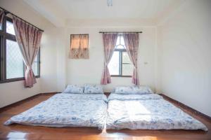 um quarto com 2 camas e 2 janelas em Huan Bei 88 Homestay em Jincheng