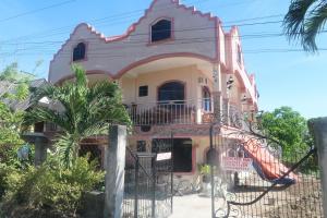 ein rosa und weißes Haus mit einer Treppe in der Unterkunft Seashore Garden Resort in Moalboal