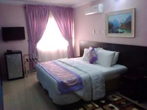 Un pat sau paturi într-o cameră la Conference Hotel and Suites Sagamu