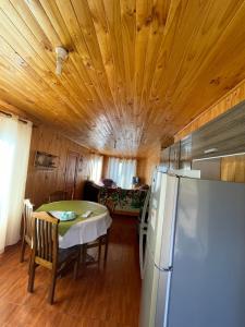 uma cozinha e sala de jantar com uma mesa e um frigorífico em Cabaña en pelluhue 5 personas em Pelluhue