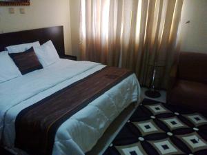Un pat sau paturi într-o cameră la Conference Hotel and Suites Sagamu