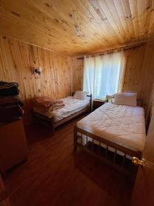 um quarto com 2 camas num chalé de madeira em Cabaña en pelluhue 5 personas em Pelluhue