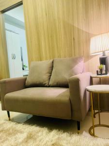 una sala de estar con un sofá y una mesa en LoveFame 8M, en Manila