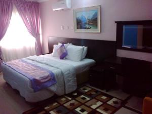 Un pat sau paturi într-o cameră la Conference Hotel and Suites Sagamu