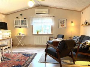 een woonkamer met stoelen, een tafel en een raam bij Holiday home PRÄSSEBO II in Eckerud