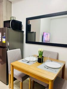 Una mesa de comedor con espejo y refrigerador. en LoveFame 8M, en Manila