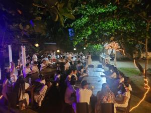 una multitud de personas sentadas en una fiesta por la noche en cabañas Juakianna, en Tolú