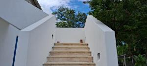 a stairway leading up to a white fence at Posada Mykonos in Bacalar