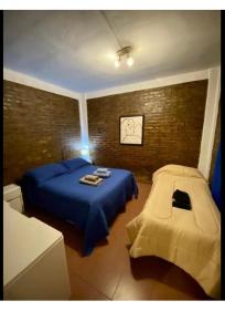 a bedroom with a blue bed and a chair at Hospedaje Noah in Ezeiza