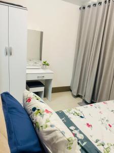 Un dormitorio con una cama, un escritorio y un espejo. en LoveFame 8M, en Manila