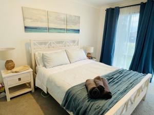 Schlafzimmer mit einem großen Bett und blauen Vorhängen in der Unterkunft Rose's Cottage in Sanctuary Point + 11 Fotos