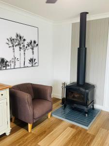 ein Wohnzimmer mit einem Sofa und einem Holzofen in der Unterkunft Rose's Cottage in Sanctuary Point