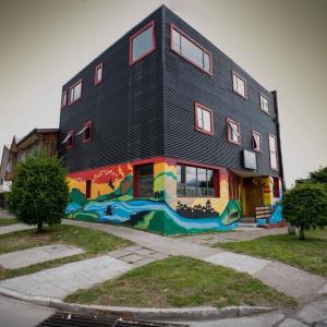 a building with a painting on the side of it at Esquina Huella Patagónica in Coihaique