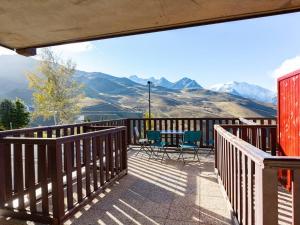 a balcony with a table and chairs and mountains at Appartement spacieux 8 pers, Peyragudes, terrasse, parking gratuit, avantages location ski - FR-1-695-44 in Germ