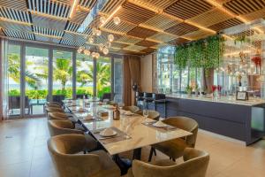 ダナンにあるOcean Villa Pool Retreat In Da Nangのダイニングルーム(長いテーブルと椅子付)