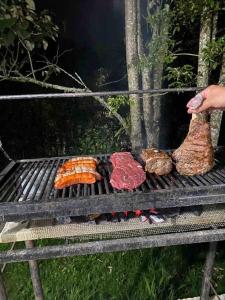 una parrilla con diferentes tipos de carne y hortalizas en Casa de campo El bosque de julia en Medellín
