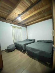 1 dormitorio con 2 camas y ventana en Casa de campo El bosque de julia en Medellín