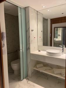 a bathroom with a sink and a toilet and a mirror at Hotel Nacional RJ - Vista Mar in Rio de Janeiro