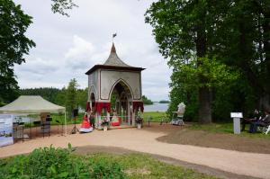 a gazebo in a park next to a lake at Holiday Apartment in Alūksne