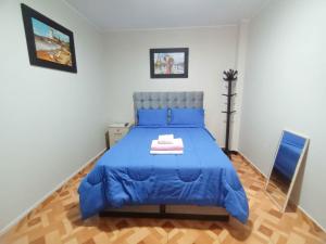 um quarto com uma cama azul e um edredão azul em "A y J Familia Hospedaje" - Free tr4nsfer from the Airport to the Hostel em Lima